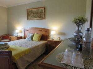 een slaapkamer met een bed en een tafel met 2 lampen bij Casa da Fonte in Monção