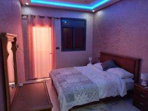 - une chambre dotée d'un lit avec une lumière bleue dans l'établissement Agadir vibes appartement, à Agadir