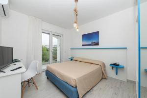 - une chambre avec un lit, un bureau et une télévision dans l'établissement Park Hotel Valle Clavia, à Peschici