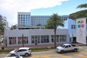 dos autos estacionados en un estacionamiento frente a un edificio en Ithaca of South Beach Hotel, en Miami Beach