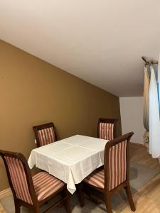 uma mesa com duas cadeiras e uma toalha de mesa branca em Saint George em Strumica