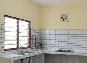 una cocina con 2 lavabos y una ventana en Al Bayt Roomstay Kaki Gunung Jerai, en Kampung Gurun