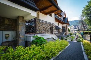 a walkway in front of a house with a balcony at TATRA Apartments Zakopane in Zakopane