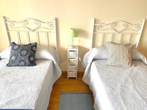 a bedroom with two beds and a night stand with a lamp at Apto La Manzanina con Parking in Villaviciosa +37 photos