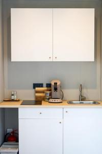 a kitchen with white cabinets and a sink at HH Gisting/Guesthouse in Hólmur