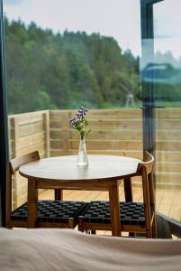 HH Gisting/Guesthouse في Hólmur: طاولة وكراسي عليها إناء ورد