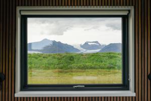 - une fenêtre dans une chambre avec vue sur les montagnes dans l'établissement HH Gisting/Guesthouse, à Hólmur