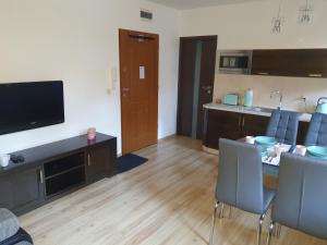 a living room with a dining table and a kitchen at Apartament 41 w Willi Józefina, parking w cenie! MBnoclegi in Szklarska Poręba