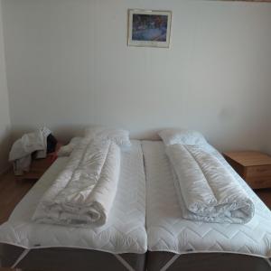 a white bed with white sheets and pillows on it at Villagehome North Jylland in Sindal