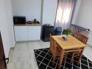 Comfort suite في القاهرة: مطبخ صغير مع طاولة وكراسي خشبية وطاولة