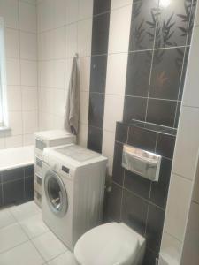 ein Badezimmer mit einer Waschmaschine und einem WC in der Unterkunft Mieszkanie Suwałki in Suwałki