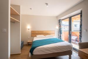 1 dormitorio con cama y ventana grande en Logis Hôtel Les Vieilles Granges, en Granges-Les-Beaumont