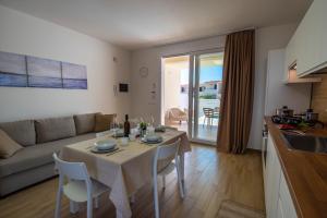 a kitchen and a living room with a table and chairs at Charming House Sveleo - SiciliaVacanza in Marzamemi