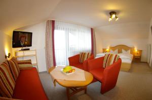 ein Hotelzimmer mit einem Sofa und einem Bett in der Unterkunft Gästehaus Wiesenhof in Fischen im Allgäu