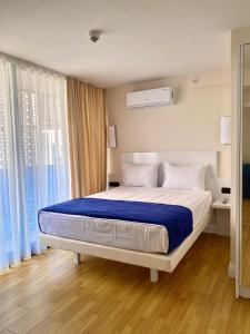 巴统Orbi Panorama Sea ​​view的卧室里有一张大床，上面铺着蓝色毯子 更多21张照片