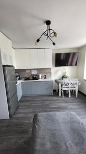 a kitchen with a refrigerator and a table in a room at DEIZY Apartamenty in Wągrowiec