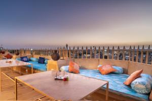 ein Zimmer mit Tischen und einem Sofa mit Kissen in der Unterkunft Hotel Heritage Haveli in Jaisalmer