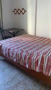 a bed sitting in a room with a table at Frente a Praia das Castanheiras in Guarapari