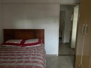 a bedroom with a bed with red pillows on it at Frente a Praia das Castanheiras in Guarapari +25 photos