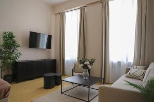 ein Wohnzimmer mit Sofa und Tisch in der Unterkunft Spacious Apartment, 3 min to U6 Alserstraße in Wien