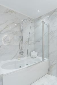 bagno bianco con doccia e vasca di LUXURY VILLAS ELENI STEFI a Limenas