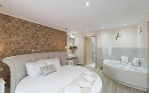 a bedroom with a white bed and a bath tub at LUXURY VILLAS ELENI STEFI in Limenas