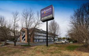 un cartello per un hotel di fronte a un edificio di InTown Suites Extended Stay Newport News VA - South a Newport News