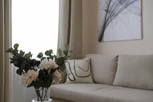 eine Vase Blumen auf einem Tisch neben einer Couch in der Unterkunft Spacious Apartment, 3 min to U6 Alserstraße in Wien