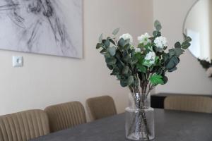 eine Vase voller weißer Blumen auf dem Tisch in der Unterkunft Spacious Apartment, 3 min to U6 Alserstraße in Wien