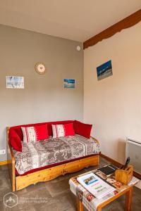 a bedroom with a bed with red pillows and a table at Au refuge d'Hirka in Termignon