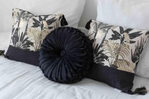 a black pillow on a bed with two pillows at Flat Design St Denis 4 personnes in Saint-Denis