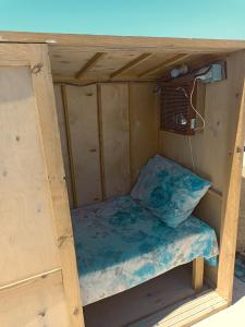 a small bed in a wooden bunk house at Nautilus Capsules in Dahab
