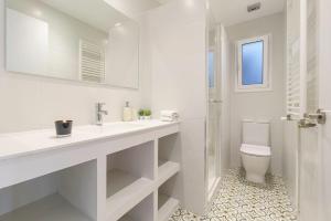 a white bathroom with a sink and a toilet at Casa Premia in Premiá de Mar