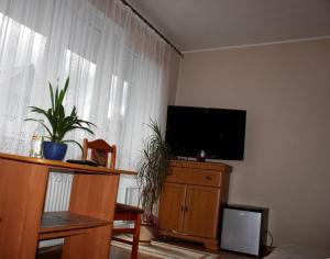 a living room with a flat screen tv on a dresser at Ugeni ,apartament in Ostrowo