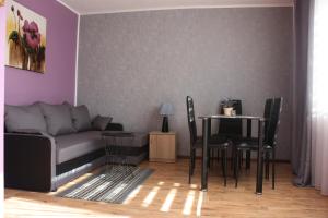 a living room with a couch and a table and chairs at Ugeni ,apartament in Ostrowo