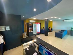 a lobby with a tv and people sitting in a room at RILL HOTEL BY UCHÔA in Teresina