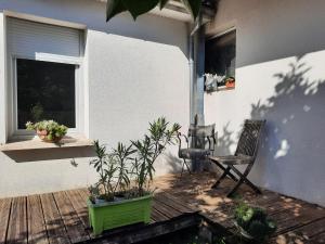 a patio with a chair and plants on a deck at O BELLOC in Lapeyrouse-Fossat