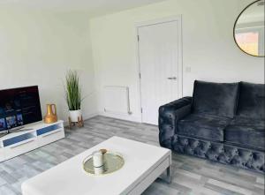Sala de estar con sofá negro y mesa de centro en Stylish new built double bed, en Mánchester