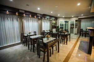a dining room with tables and chairs and windows at Hotel Morava - Šabac in Šabac