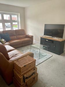 a living room with a couch and a flat screen tv at Robins Nest Guest House in Great Meols