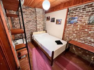 Habitación pequeña con cama en una pared de ladrillo en Rooms Nesti INSIDE OF CASTLE, en Krujë