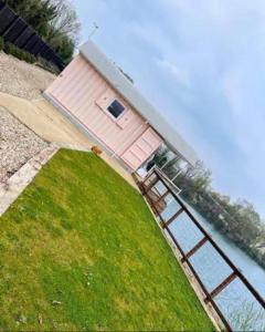 a pink house sitting on top of a body of water at Lake View Lodge Pod in Chichester