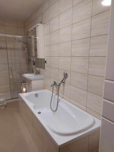 a bathroom with a bath tub and a sink at Dom Tatrzański Widok in Bustryk