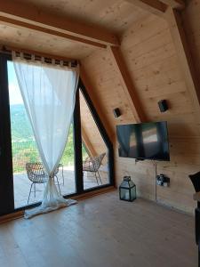 a living room with a large window and a tv at Stone Chalets - TERRA in Jajce