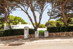 Un cementerio con lápidas delante de un árbol en Villa Menorca Ses Roques Vermelles by Mauter Villas, en Cala Morell