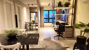 un soggiorno con tavolo, sedie e scrivania di Loft de Luxo c/ Home Office ao lado Shopping CG. a Campo Grande