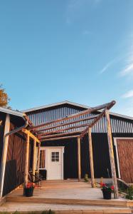 a large black building with a wooden deck at Hidden Island Laukanharju Glamping in Savonlinna