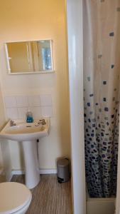a white bathroom with a sink and a shower at The Kathrene in Fleetwood