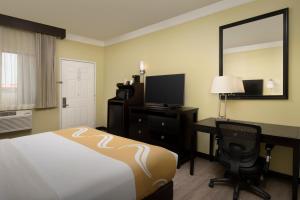 a hotel room with a bed and a desk and a mirror at Quality Inn & Suites Gallup I-40 Exit 20 in Gallup