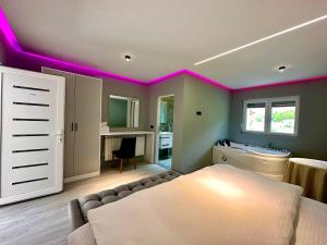 een kamer met paarse verlichting aan het plafond bij Breezy Hotel in Valbonë